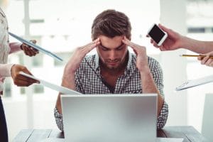 איש מול מחשב מנסה להתמודד עם לחץ בעבודה